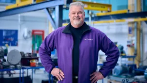 Mies poseeraa nosturihallissa