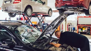 mies korjaa henkilöautoja