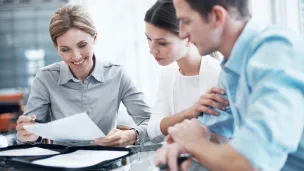 iloiset ihmiset tärkeän paperin äärellä toimistossa