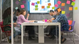 Ihmisiä pöydän ääressä ryhmätyössä